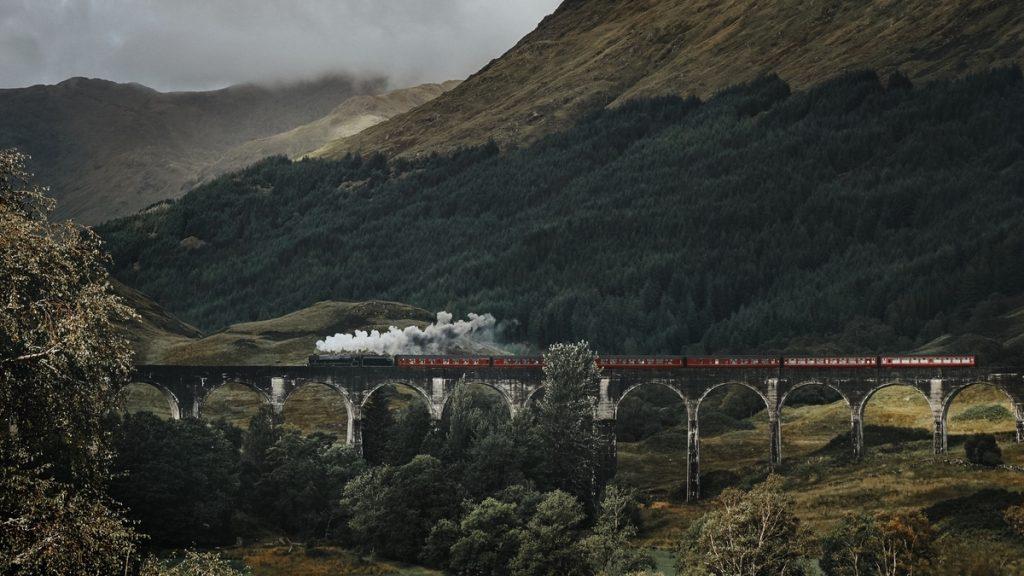 Painting of a steam train in the Scottish Mountains